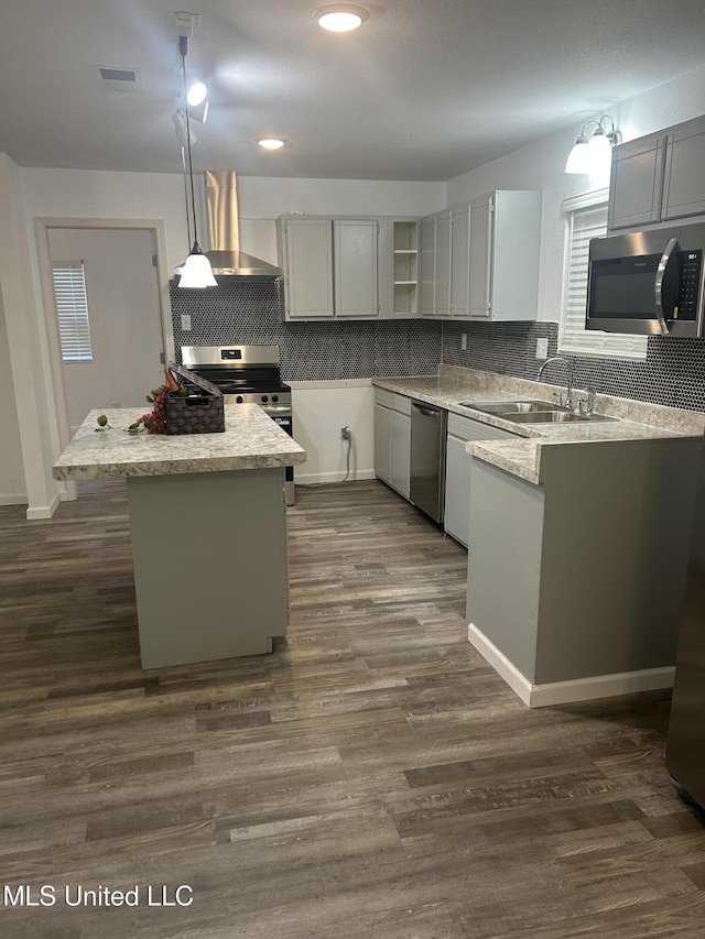 5736 Eastwood Dr, Moss Point, MS 39563 - kitchen with stainless steel appliances, wall chimney range hood, decorative backsplash, hanging light fixtures, and recessed lighting