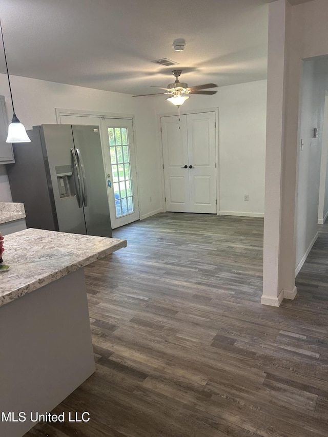 5736 Eastwood Dr, Moss Point, MS 39563 - kitchen with stainless steel fridge, a ceiling fan, dark wood-style floors, light stone countertops, and pendant lighting