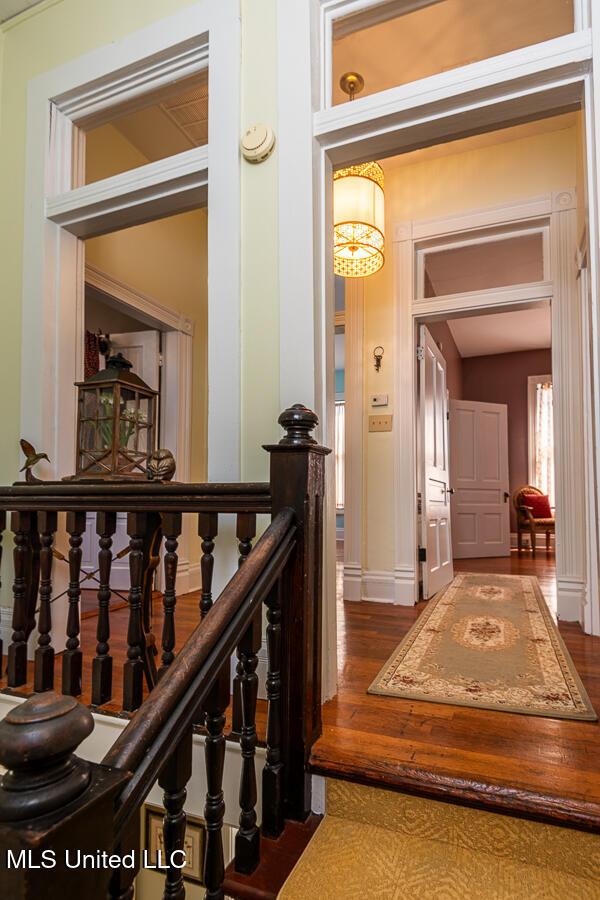 612 State St, Natchez, MS 39120 - corridor featuring wood finished floors, a chandelier, and baseboards