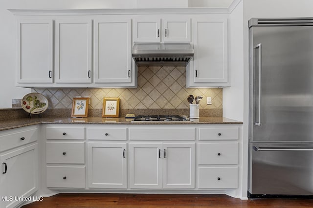 kitchen featuring stone counters, white cabinets, wall chimney exhaust hood, and appliances with stainless steel finishes