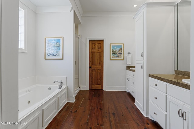 full bathroom with a shower stall, a whirlpool tub, ornamental molding, vanity, and wood-type flooring