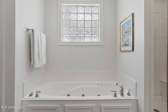 bathroom featuring a tub with jets and a shower