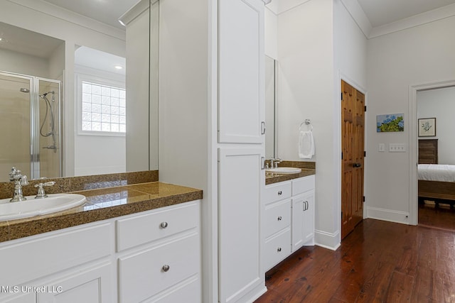 ensuite bathroom featuring a shower stall, ornamental molding, ensuite bathroom, wood finished floors, and vanity