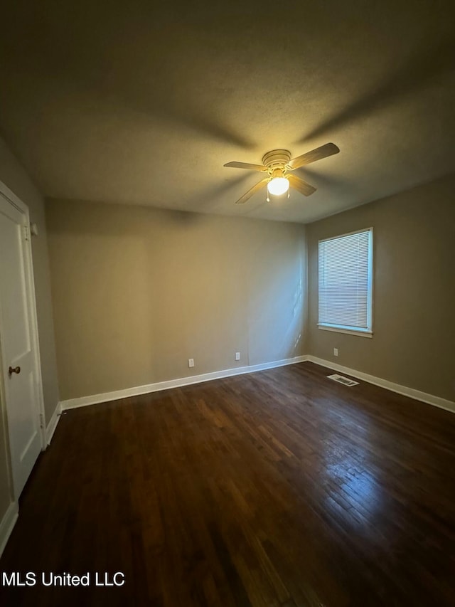 unfurnished room with ceiling fan and dark hardwood / wood-style floors