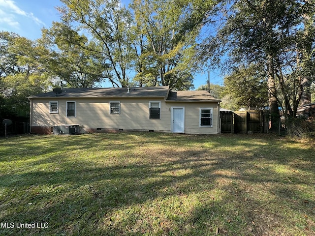 rear view of property featuring a yard and central air condition unit