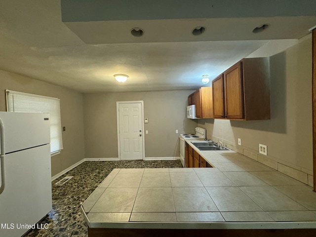 kitchen with tile counters, tile patterned flooring, white appliances, and sink