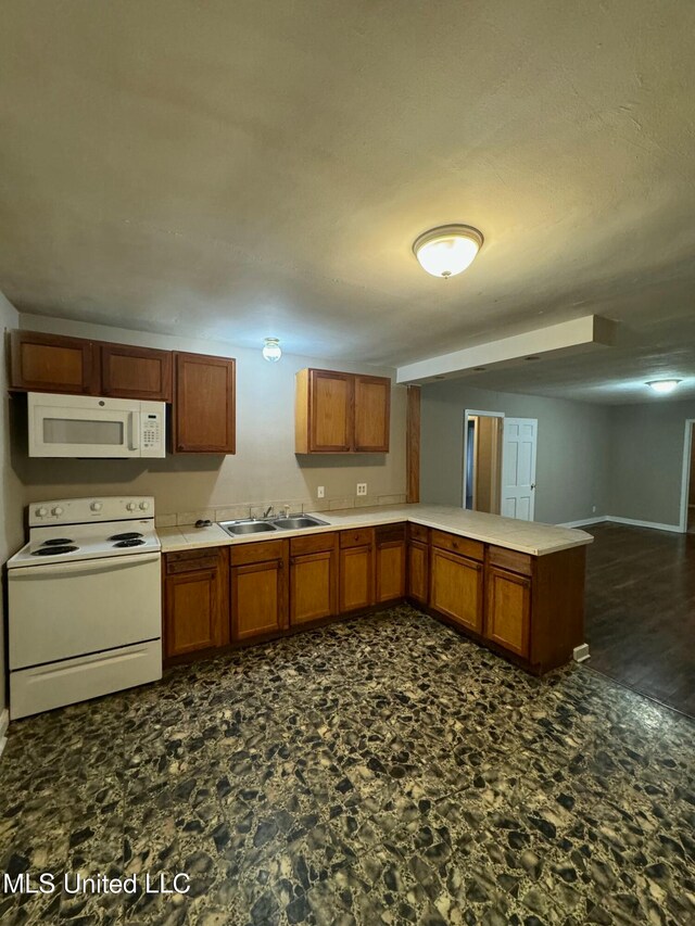 kitchen featuring kitchen peninsula, sink, and white appliances