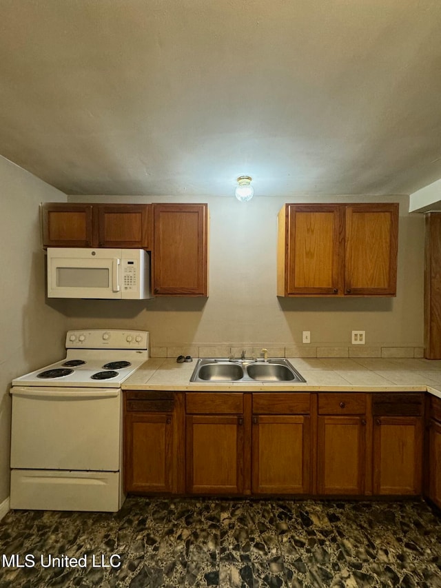 kitchen featuring lofted ceiling, white appliances, and sink