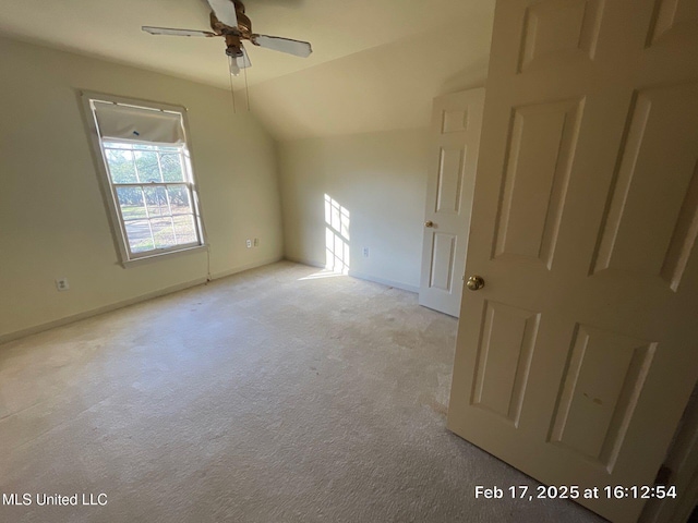 interior space with ceiling fan, baseboards, and lofted ceiling