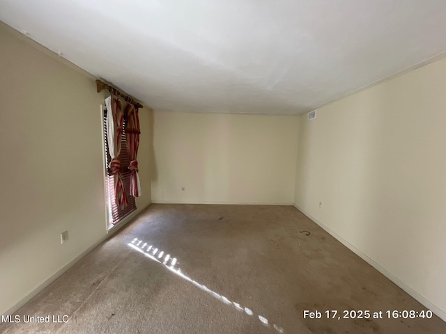 carpeted spare room with visible vents and baseboards