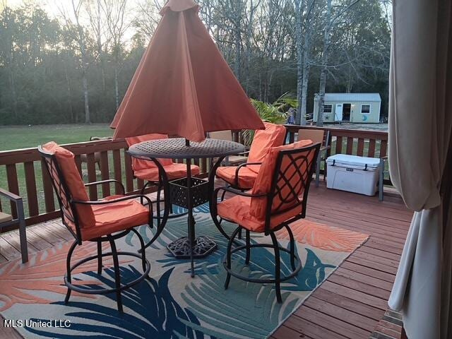 9900 Little Buck, Vancleave, MS 39565 - wooden deck featuring outdoor dining space and view of scattered trees