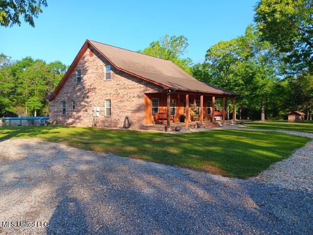9900 Little Buck, Vancleave, MS 39565 - view of home's exterior featuring covered porch, a yard, and stone siding