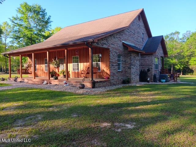 9900 Little Buck, Vancleave, MS 39565 - view of front of home with a porch, a front lawn, and board and batten siding