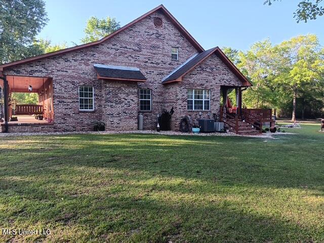 9900 Little Buck, Vancleave, MS 39565 - rear view of house with a lawn, brick siding, and central AC unit