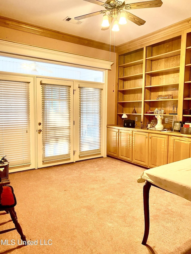 interior space with built in shelves, light colored carpet, and ornamental molding