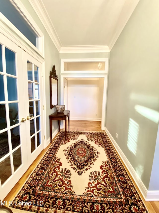 corridor with french doors, crown molding, and wood-type flooring