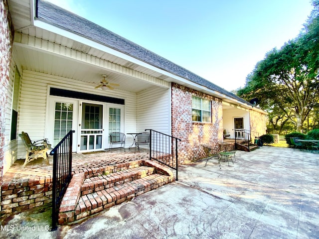 view of exterior entry with ceiling fan and a patio area