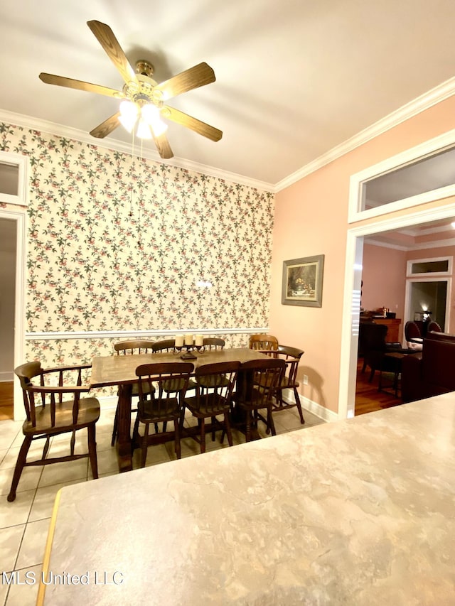 tiled dining room featuring ceiling fan and ornamental molding