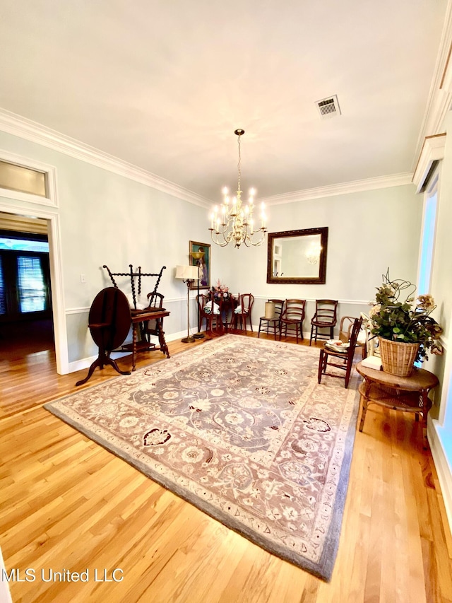 dining space featuring a chandelier, hardwood / wood-style flooring, and ornamental molding