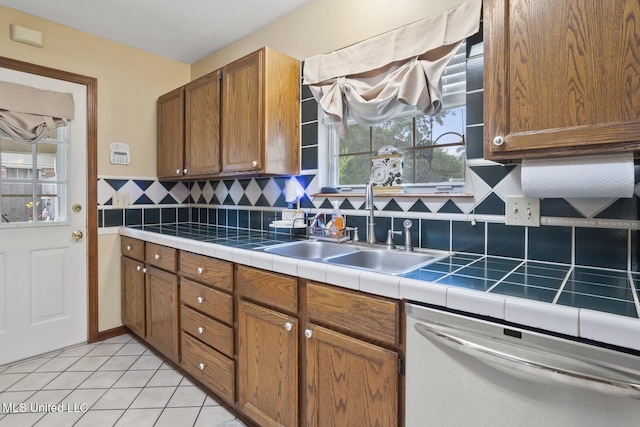 725 Bay Tree Dr, Flowood, MS 39232 - kitchen with dishwasher, decorative backsplash, brown cabinetry, and light tile patterned flooring