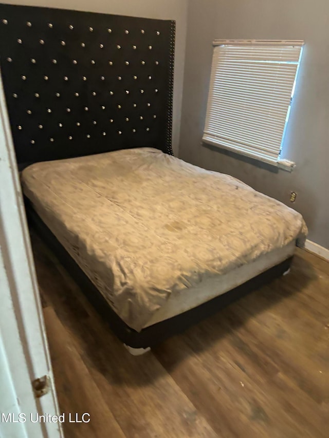 bedroom with dark hardwood / wood-style flooring