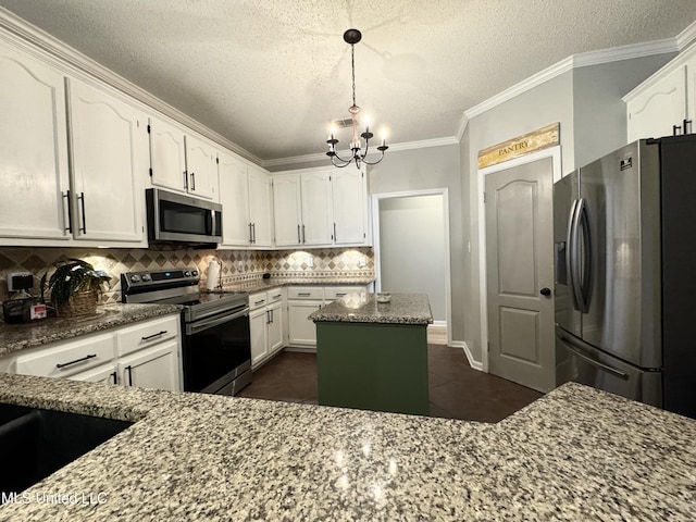 kitchen featuring stone counters, a kitchen island, white cabinetry, stainless steel appliances, and crown molding