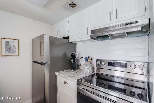 138 Molokai Vlg Unit J, Diamondhead, MS 39525 - kitchen featuring stainless steel appliances, under cabinet range hood, white cabinets, and light stone counters