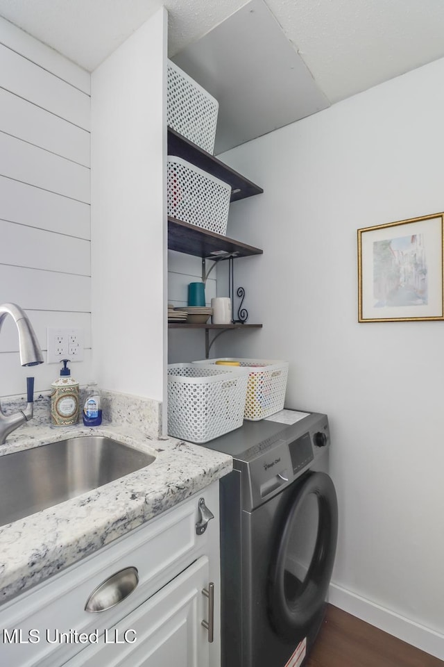 138 Molokai Vlg Unit J, Diamondhead, MS 39525 - clothes washing area featuring cabinet space, baseboards, and dark wood-style floors