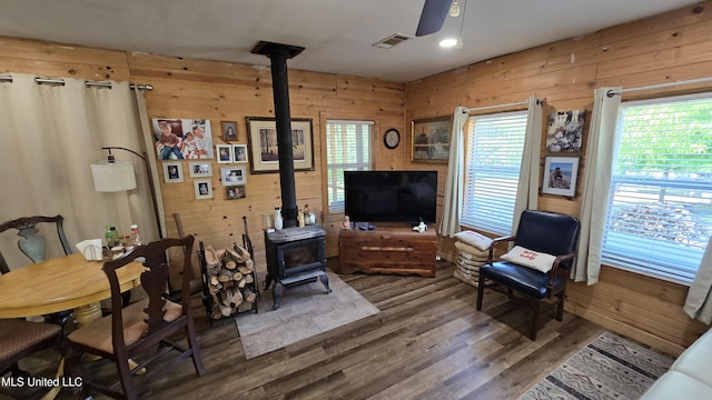 22386 Ms Highway 32, Oakland, MS 38948 - living area featuring visible vents, a ceiling fan, wood finished floors, wood walls, and a wood stove