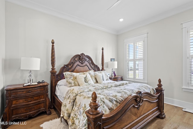 bedroom featuring light wood-type flooring and crown molding