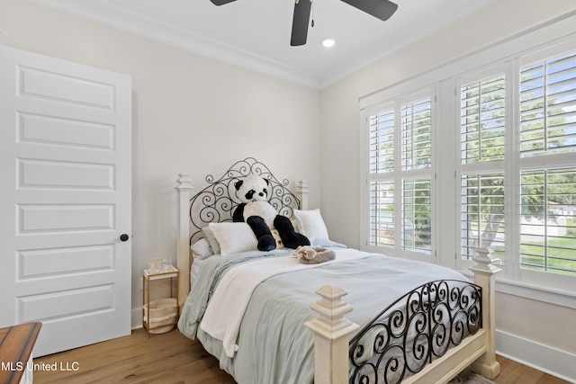 bedroom with ceiling fan, multiple windows, wood-type flooring, and crown molding