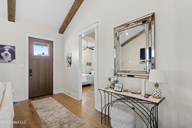 entrance foyer with ceiling fan, light wood-type flooring, and vaulted ceiling with beams