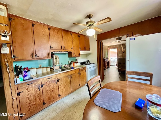 kitchen with white appliances, ceiling fan, and sink