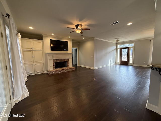 unfurnished living room featuring ceiling fan, dark hardwood / wood-style flooring, crown molding, and a fireplace