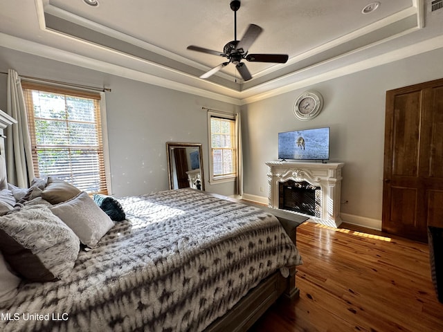 121 Vinca Dr, Madison, MS 39110 - bedroom with a raised ceiling, a fireplace, hardwood / wood-style flooring, multiple windows, and ornamental molding