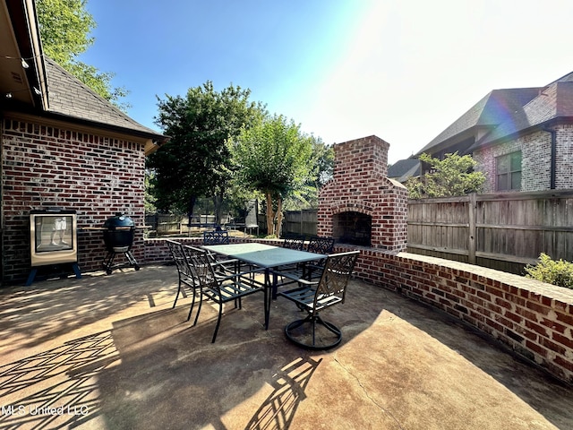 121 Vinca Dr, Madison, MS 39110 - view of patio / terrace featuring an outdoor brick fireplace, a fenced backyard, outdoor dining space, and area for grilling