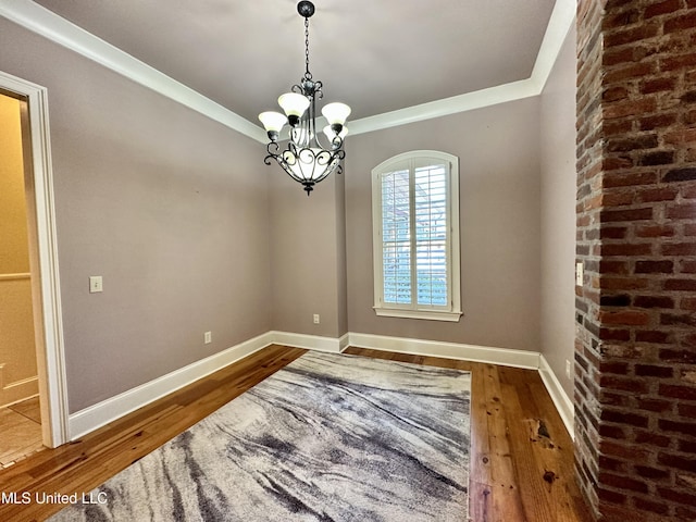 121 Vinca Dr, Madison, MS 39110 - unfurnished room with hardwood / wood-style floors, a chandelier, baseboards, brick wall, and ornamental molding