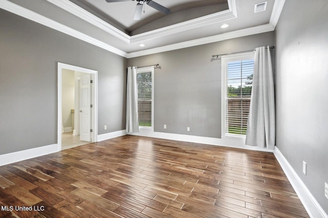 spare room with ceiling fan, crown molding, a raised ceiling, and dark hardwood / wood-style floors