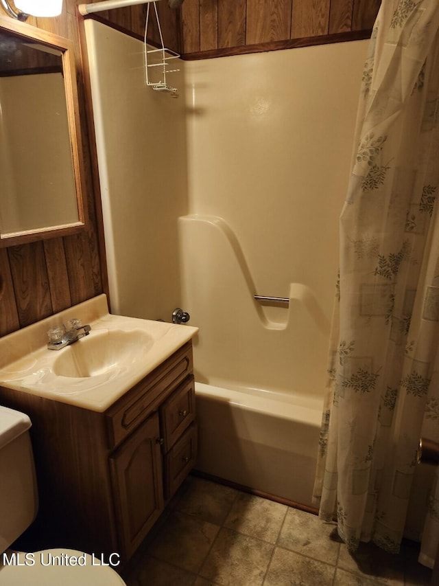 full bathroom featuring toilet, vanity, shower / tub combo with curtain, and wood walls