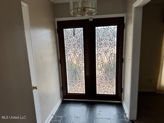 foyer featuring french doors and a notable chandelier