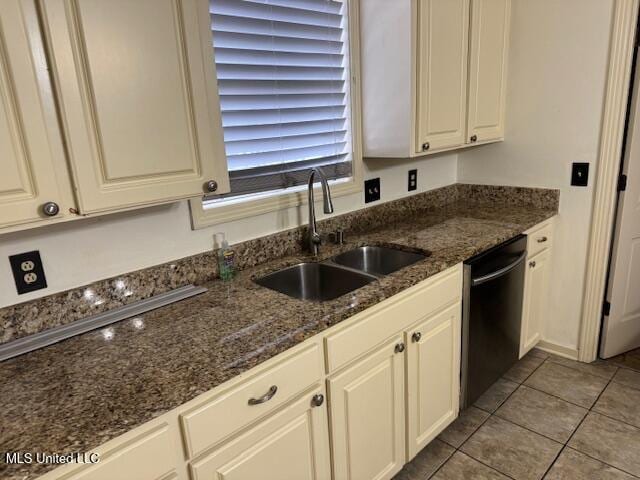 kitchen with dishwasher, sink, dark stone countertops, white cabinets, and light tile patterned floors