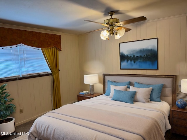 carpeted bedroom featuring ceiling fan and wood walls