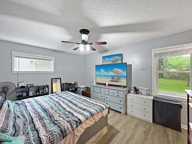 1008 Normandy Dr, Clinton, MS 39056 - bedroom with light wood-style floors, a textured ceiling, and a ceiling fan