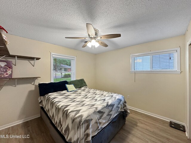 1008 Normandy Dr, Clinton, MS 39056 - bedroom with wood finished floors, baseboards, a textured ceiling, and a ceiling fan