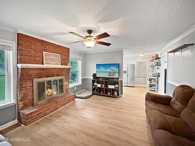 1008 Normandy Dr, Clinton, MS 39056 - living area with ceiling fan, light wood-style flooring, a fireplace, a textured ceiling, and ornamental molding