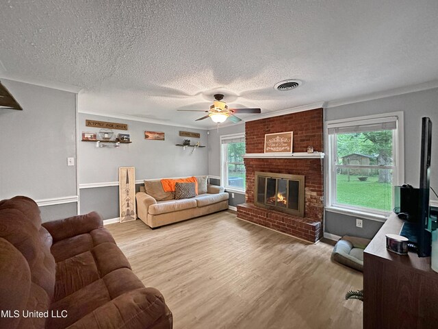 1008 Normandy Dr, Clinton, MS 39056 - living area featuring a textured ceiling, a ceiling fan, wood finished floors, a brick fireplace, and baseboards