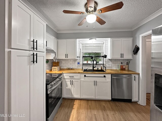 1008 Normandy Dr, Clinton, MS 39056 - kitchen featuring butcher block counters, stainless steel appliances, a sink, a textured ceiling, and light wood-type flooring