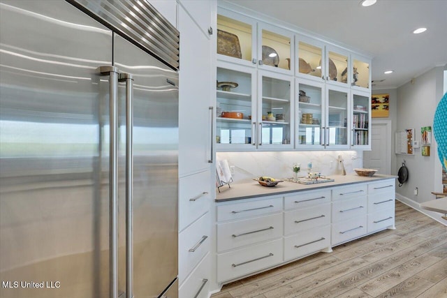 205 Audubon Point Dr, Brandon, MS 39047 - kitchen with light wood-type flooring, built in fridge, glass insert cabinets, recessed lighting, and white cabinetry