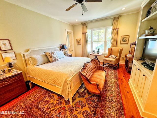 bedroom featuring ceiling fan, wood-type flooring, and ornamental molding