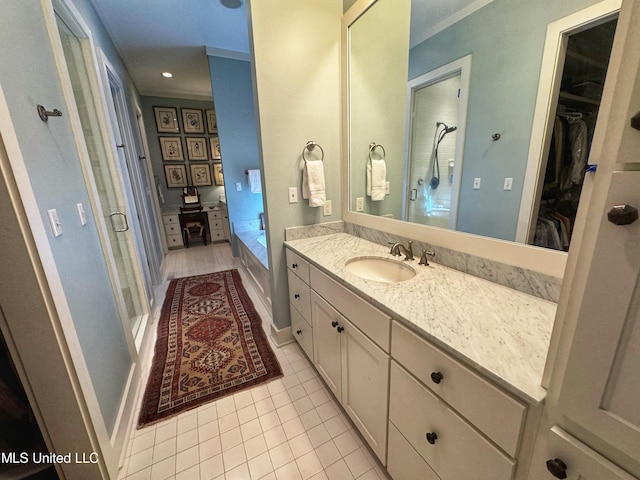 full bath with tile patterned floors, vanity, a stall shower, a spacious closet, and a garden tub
